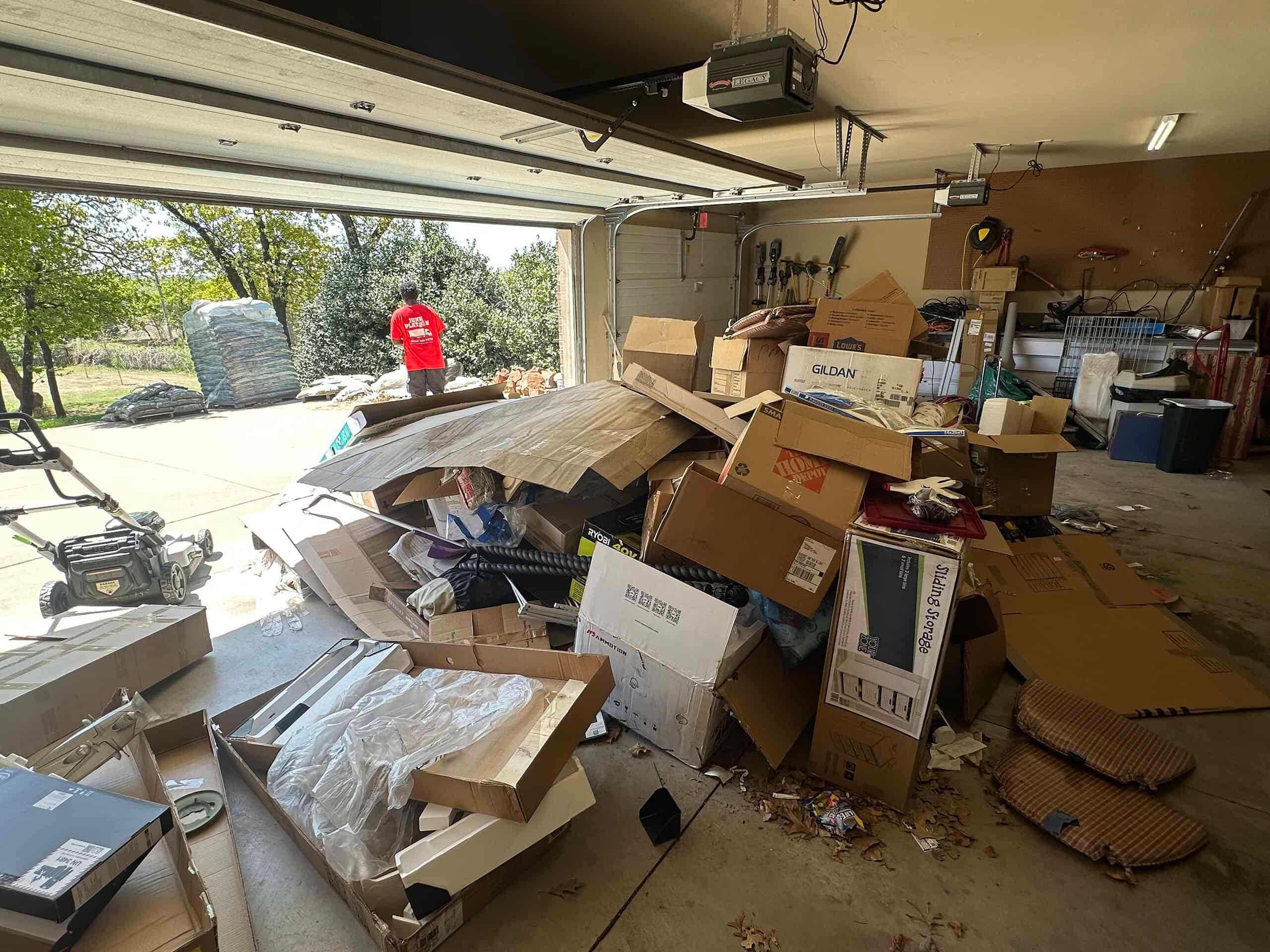 A garage in Edmond packed with boxes, furniture and loose junk before a Junk Platoon cleanout